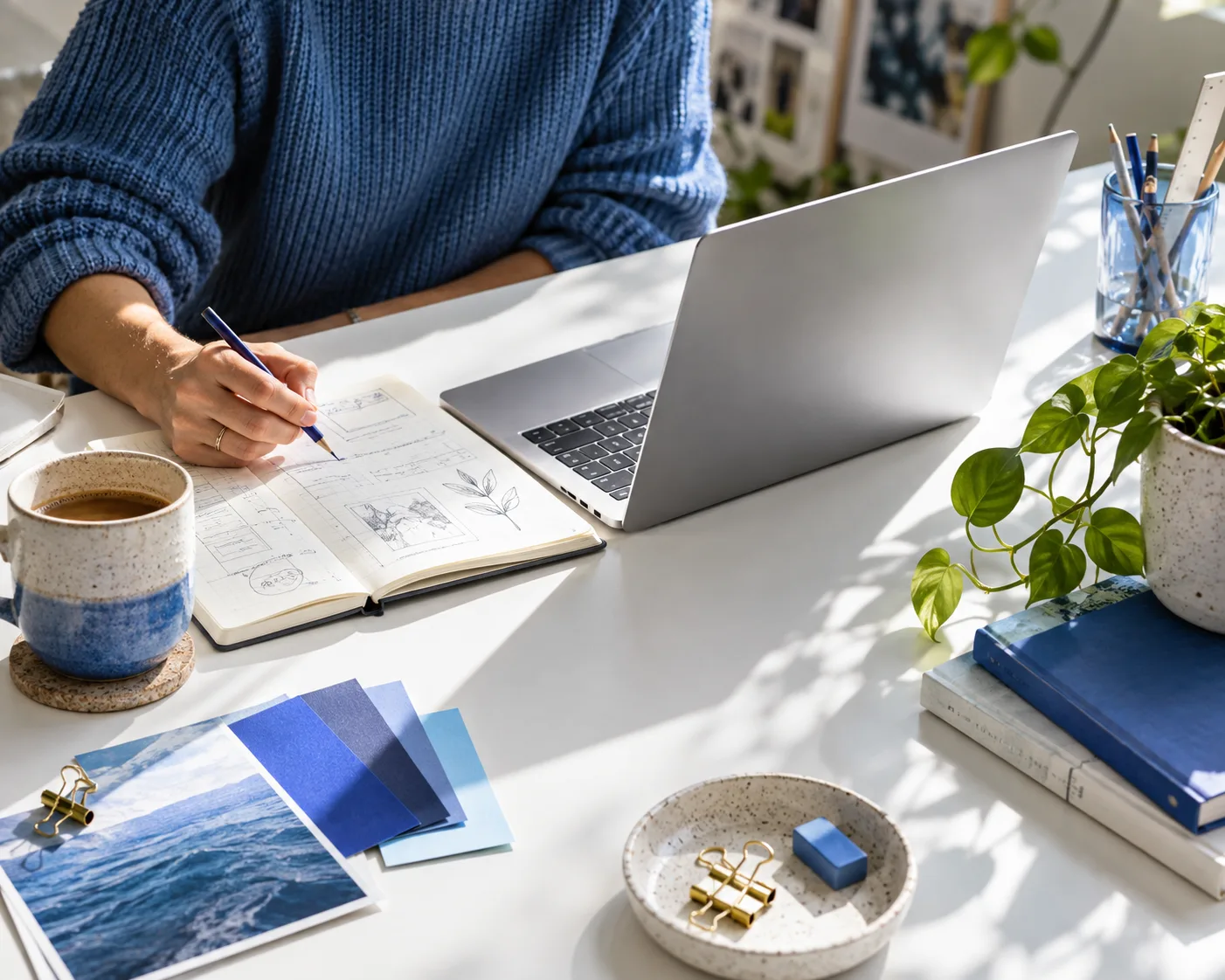 A creative workspace with a laptop and sketchbook